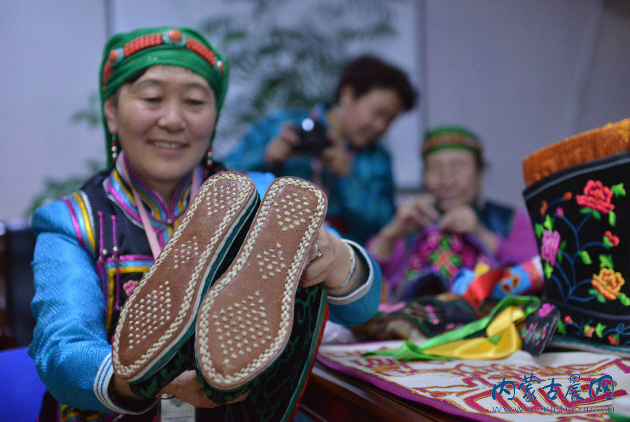 传承人集体展示哈斯琪琪格（前排中）创作的蒙古族刺绣巨幅作品《吉祥八宝》。