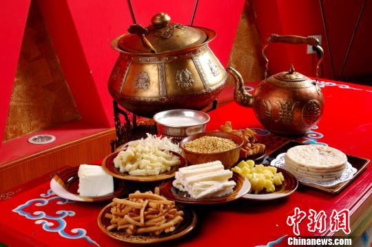 资料图片。图为用蒙古元素餐饮器皿所装载的传统草茶，其中包含奶茶、奶食品、炸果条、蒙古馅饼、炒米等食物。　内蒙古饭店 摄