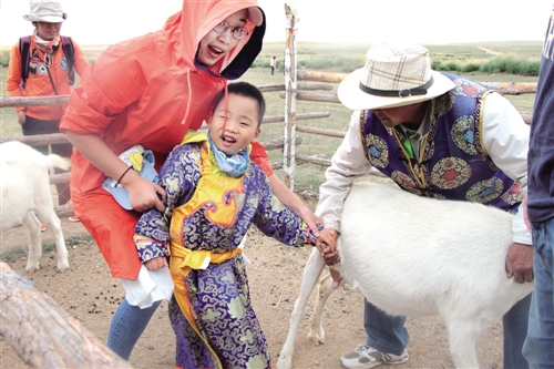 游客在宝音敖其尔家体验做一天蒙古人旅游项目。